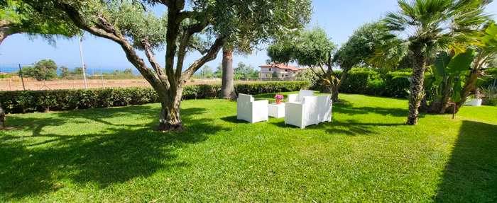 Ampio prato del giardino di Villa Ilaria con area relax